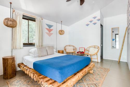 - une chambre avec un grand lit et une couverture bleue dans l'établissement Selina Tamarindo, à Tamarindo