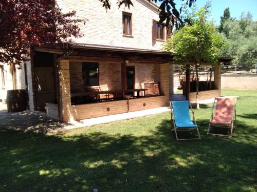 two chairs sitting in the grass in front of a house at Casa LEPRICE in SantʼElpidio a Mare