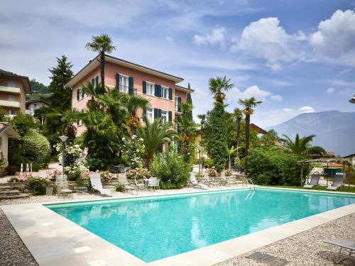 a swimming pool in front of a house at Albergo Garnì Villa Moretti in Riva del Garda