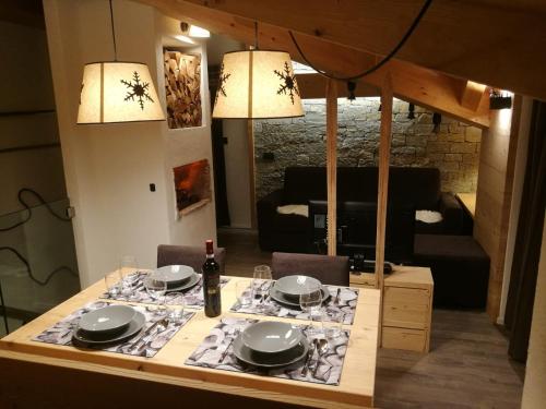 a dining room table with plates and a bottle of wine at CHALET REMI-STELLA ALPINA in Livigno
