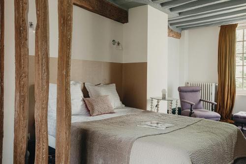 - une chambre avec un lit et une chaise violette dans l'établissement La Dime de Giverny - Chambres d'hôtes, à Giverny