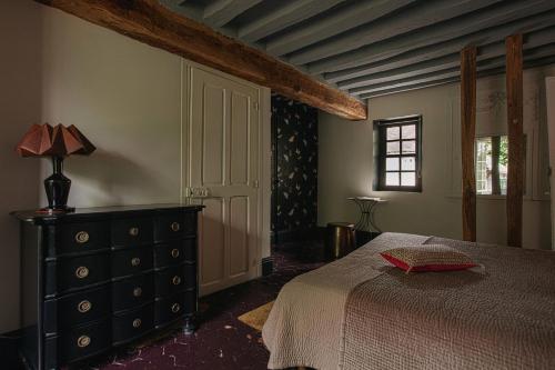 a bedroom with a bed and a dresser and a window at La Dime de Giverny - Chambres d'hôtes in Giverny