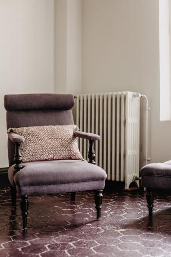 - un salon avec une chaise et un radiateur dans l'établissement La Dime de Giverny - Chambres d'hôtes, à Giverny