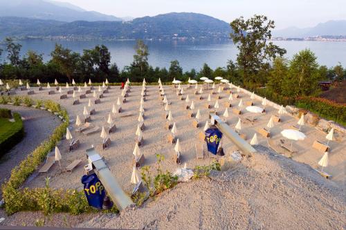 a long row of umbrellas in a field next to a lake at Residence Carl&Do in Baveno