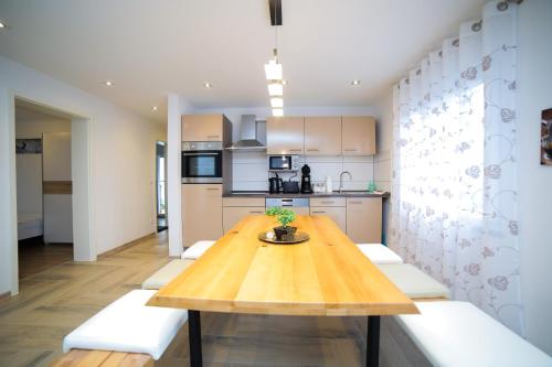 a kitchen with a wooden table and white cabinets at Apartment Claudia in Sinsheim