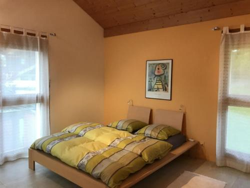 a bed sitting in a room with a window at Carrera - Ferienhaus mit Traumgarten (120m2) für max. 2 Personen in Valendas