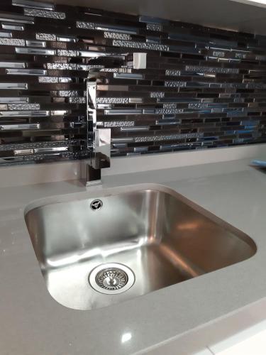 a stainless steel sink in a kitchen with a wall at Nuevo junto a Catedral in Murcia