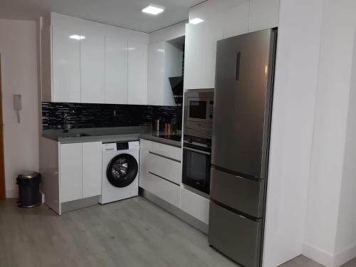 a kitchen with a refrigerator and a washing machine at Nuevo junto a Catedral in Murcia