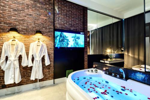 bagno con vasca e TV di Starowiślna VIP Apartamenty JACUZZI a Cracovia