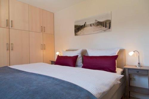 a bedroom with a large bed with two red pillows at Traumblick Ferienwohnung in Sauzin