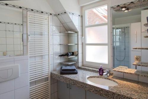 a white bathroom with a sink and a window at Traumblick Ferienwohnung in Sauzin