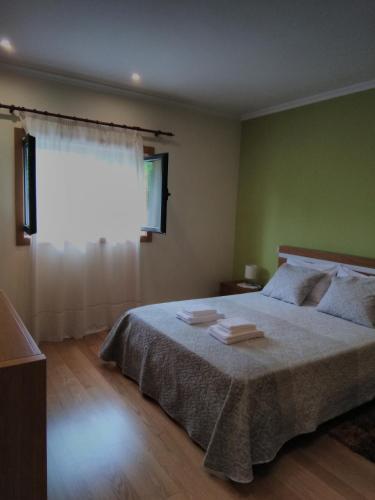 a bedroom with a large bed and a window at BellaVista Alojamento in Arouca