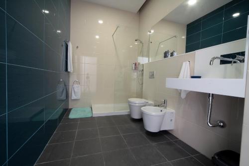 a bathroom with a shower and a toilet and a sink at Marketplace Apartment 1 in Ponta Delgada