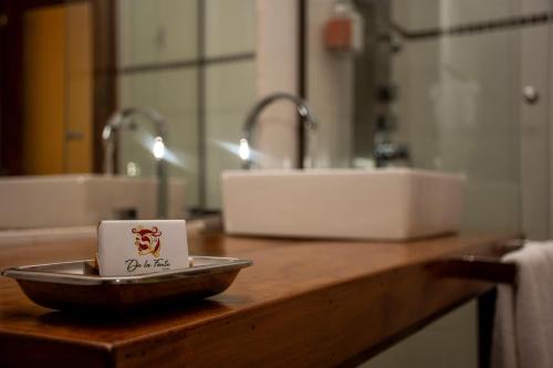 a cup on a plate on a counter in a bathroom at Boutique Hotel De La Fonte & Restaurant in Puerto Iguazú