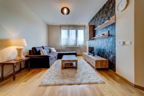 uma sala de estar com um sofá e uma mesa em Luxury Kalman Centar Apartman em Zlatibor