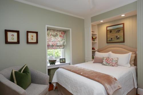 a bedroom with a bed and a chair and a window at Woolverton Inn in Stockton