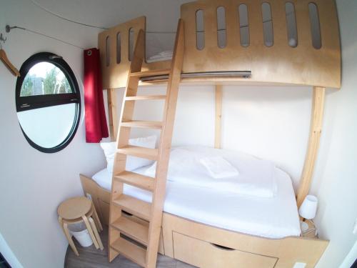 a small bedroom with a bunk bed and a ladder at slube am Yachthafen Greifswald in Greifswald