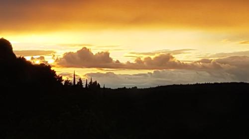 a sunset with clouds in the sky at Un petit nid dans la garrigue in Saint-Pierre-des-Champs