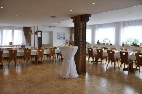 un salón de banquetes con mesas y sillas y un centro de mesa en Hotel Berggarten, en Brotterode