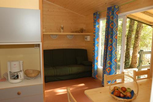 una cocina y una sala de estar en una casa pequeña en Chalet de La Héronnière, en Chef-Boutonne