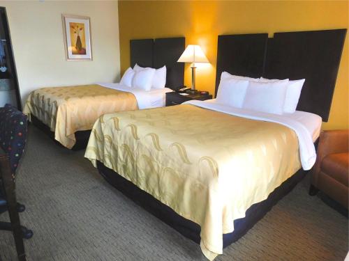 a hotel room with two beds and a chair at Quality Inn Jonesville I-77 in Jonesville