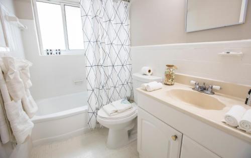 a white bathroom with a toilet and a sink at Beachside All Suites Hotel in Miami Beach