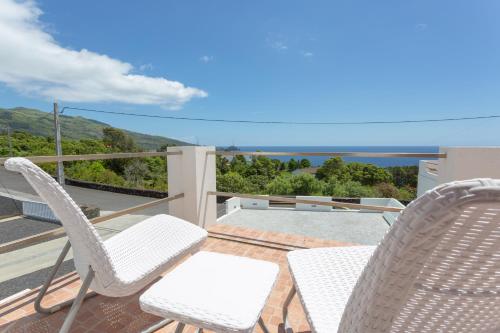a patio with two chairs and a table on a balcony at 35th Atlantic View in Lajes do Pico