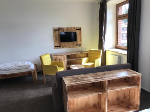 a room with a couch and chairs and a tv at Bezručova škola in Staré Hamry