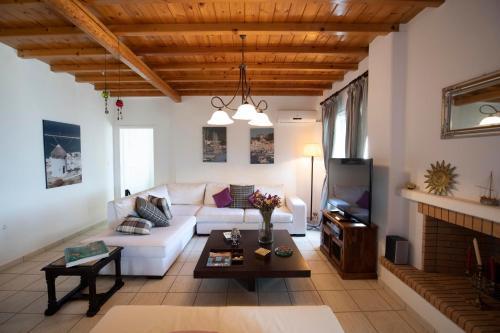 ein Wohnzimmer mit einer weißen Couch und einem Kamin in der Unterkunft Siourdas Mykonos Villas in Agios Sostis Mykonos