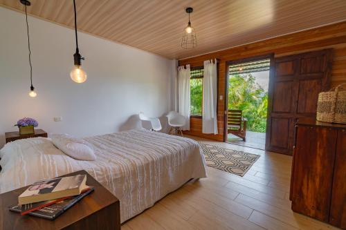 a bedroom with a bed and a table and a window at Ladera Hotel in Turrialba