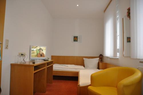Schlafzimmer mit einem Bett, einem Schreibtisch und einem Stuhl in der Unterkunft Hotel Berggarten in Brotterode