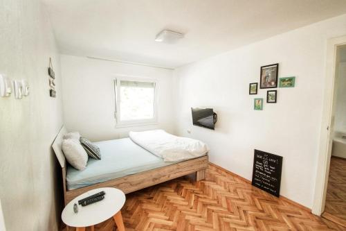 a small bedroom with a bed and a table at Riverside Pool Villa in Novi Sad
