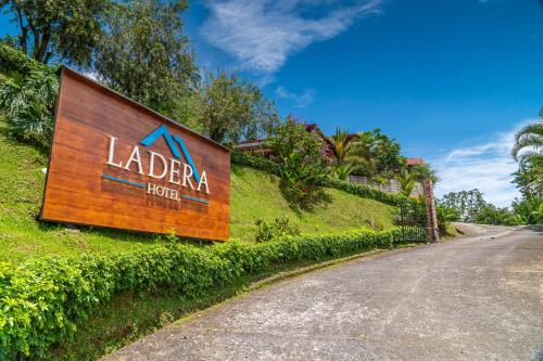 a sign for aldar hotel on the side of a road at Ladera Hotel in Turrialba