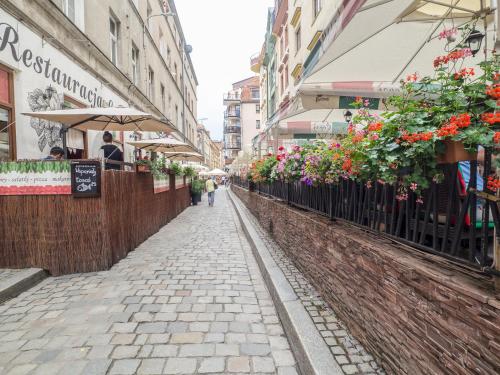una strada in una città con fiori su una recinzione di Best Apartments Więzienna Monkeys a Breslavia