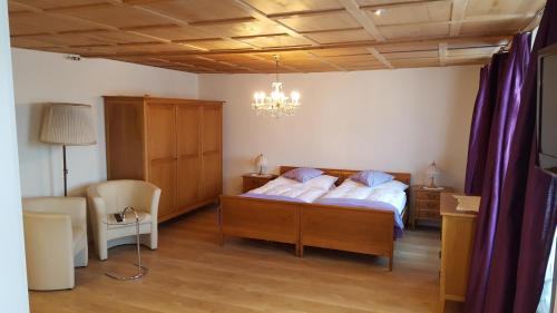 a bedroom with two beds and a chandelier at Gasthof Rössli Gondiswil in Gondiswil
