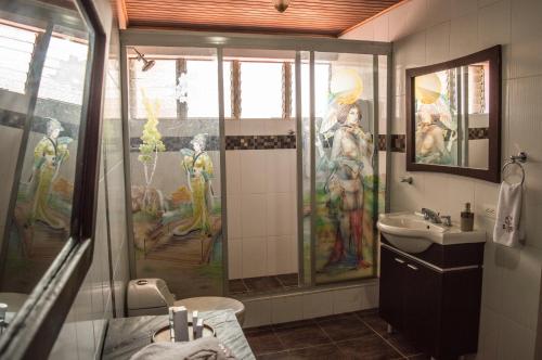łazienka z malowidłem na ścianie i umywalką w obiekcie El Virrey Hotel Boutique w mieście Honda