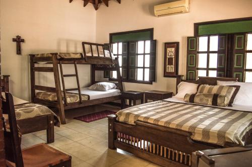 a bedroom with two bunk beds and a chair at El Virrey Hotel Boutique in Honda