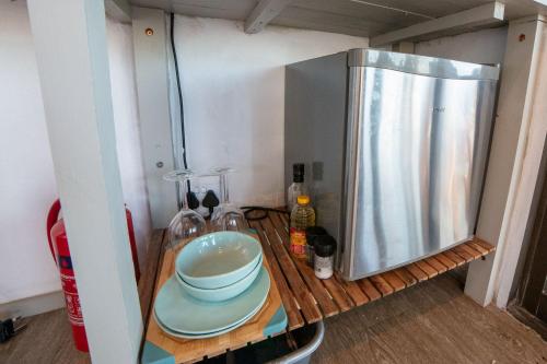 einen Holztisch mit einer Schüssel auf einem Kühlschrank in der Unterkunft Casa Narinho in Praia do Tofo