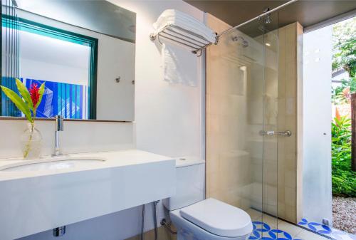 a bathroom with a toilet and a sink and a shower at Hotel Aldeia de Sahy in Barra do Sahy