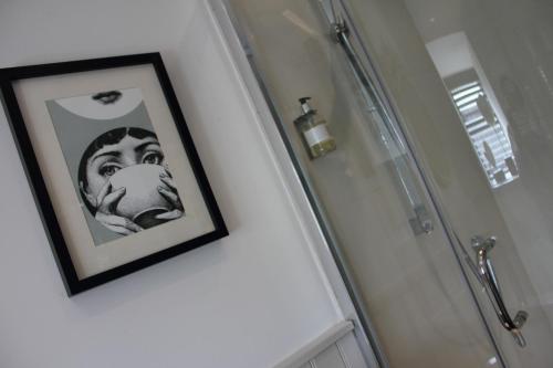 a picture of a man on a wall next to a shower at The Spread Eagle in Clitheroe