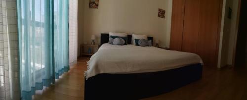 a bedroom with a bed with pillows on it at Flat Sines in Sines