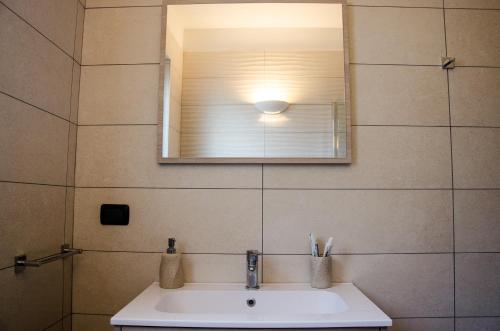 a bathroom with a sink and a mirror at AnMa Cottages The Secret Garden in Pianello Del Lario