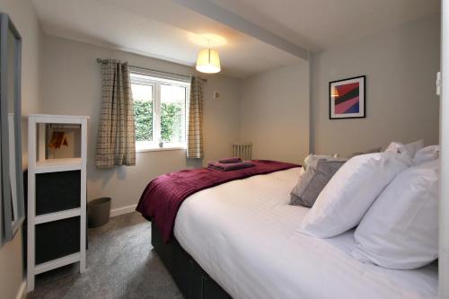 - une chambre avec un grand lit blanc et une fenêtre dans l'établissement Crewe Short Lets 4 Victoria Court, Crewe, à Crewe