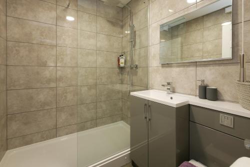 y baño con bañera, lavamanos y ducha. en Crewe Short Lets 4 Victoria Court, Crewe en Crewe