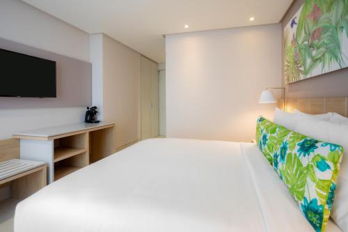 a bedroom with a large bed and a tv at Mia Hotel Choco in Quibdó
