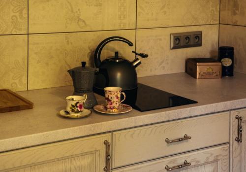 a kitchen counter with a tea kettle and two cups at Leśny Ogród in Lanckorona