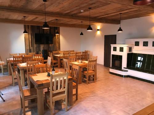 un restaurante con mesas y sillas de madera y chimenea en Bezručova škola en Staré Hamry