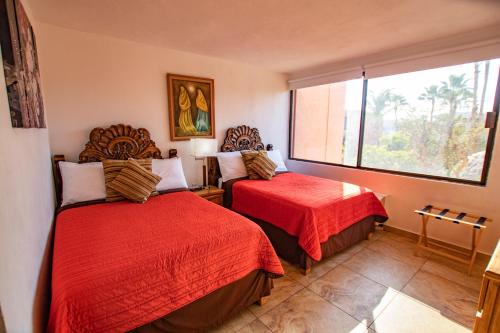 Habitación de hotel con 2 camas y ventana en Cabo Cottage Authentic Mexican Design Overlooking The Beach en Cabo San Lucas