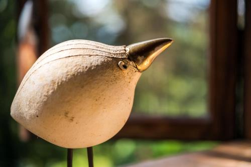 a statue of a bird sitting on a stand at Leśny Ogród in Lanckorona