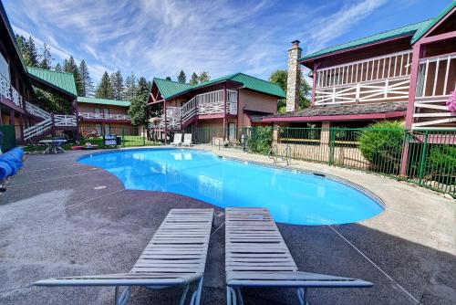 a swimming pool with two lounge chairs in front of a house at AbbyCreek Inn in Winthrop